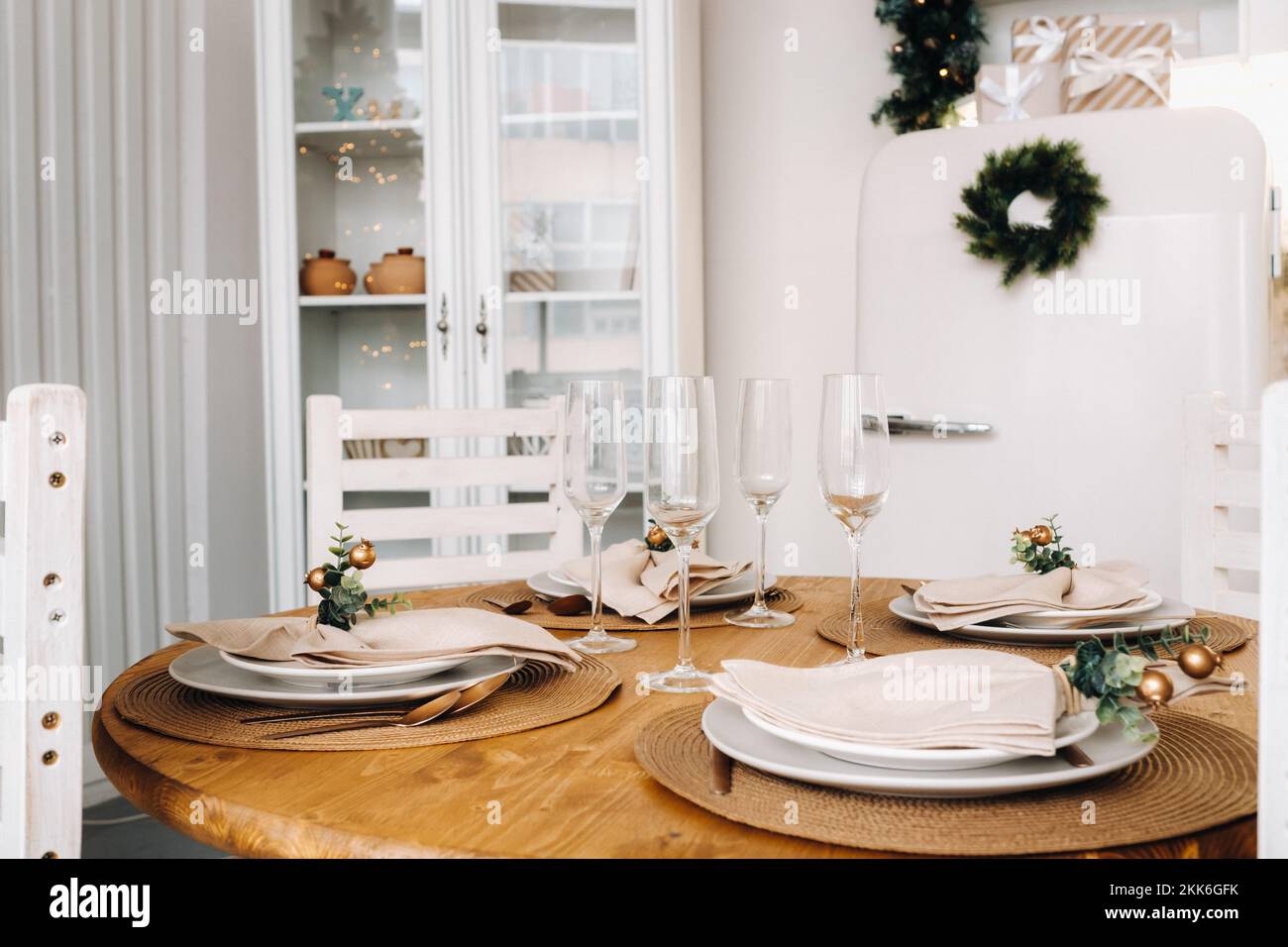 Weihnachtstischdekoration in der Küche, Banketttisch mit Gläsern vor dem Servieren des Essens, Nahaufnahme des Weihnachts-Dinner-Tisches mit saisonalen Stockfoto