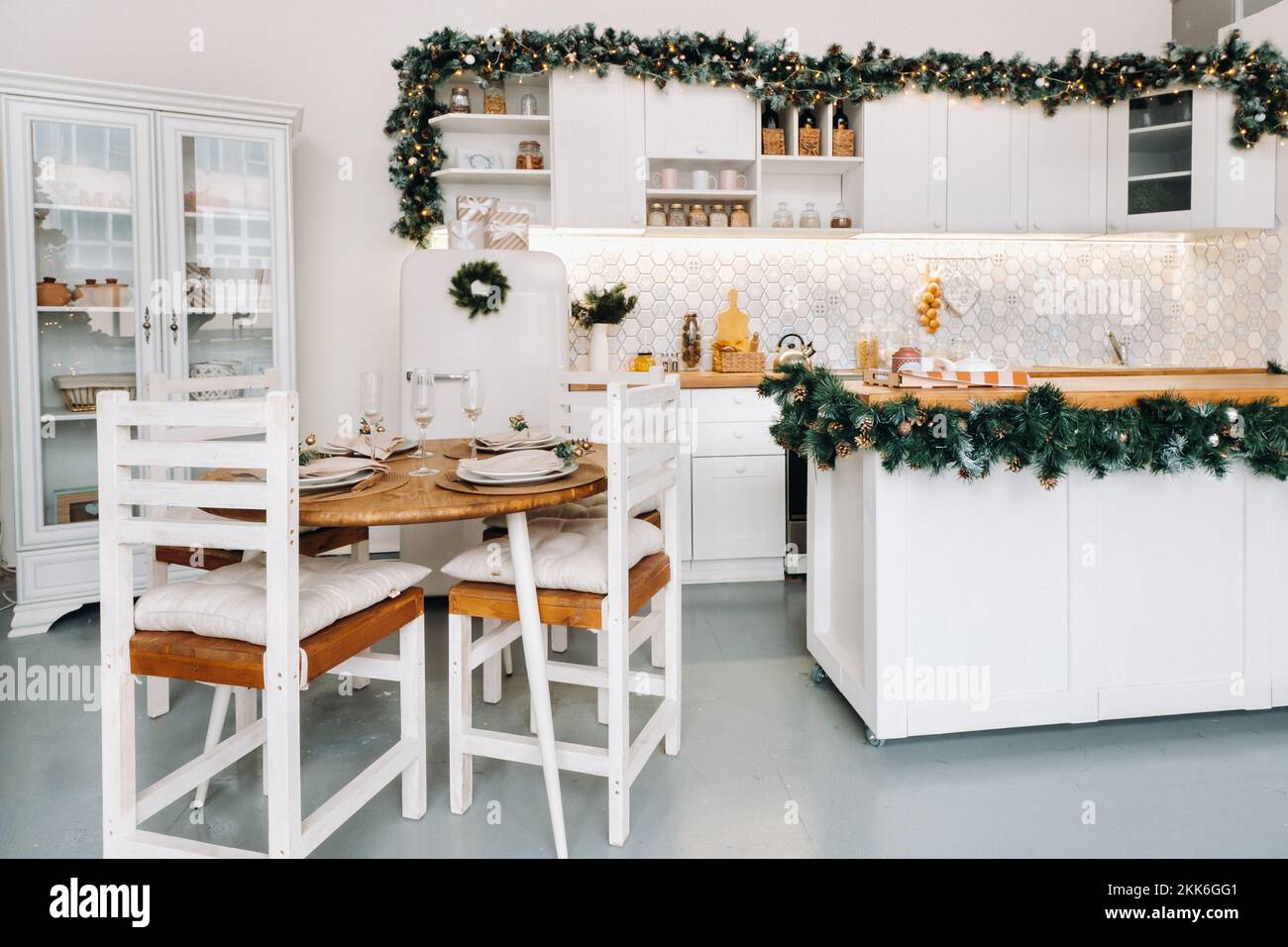 Weihnachtstischdekoration in der Küche, Banketttisch mit Gläsern vor dem Servieren des Essens, Nahaufnahme des Weihnachts-Dinner-Tisches mit saisonalen Stockfoto