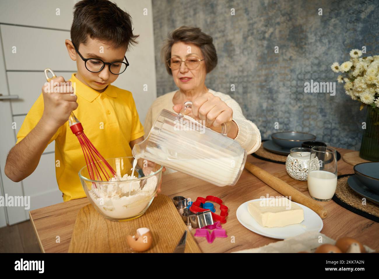 Der Junge kocht köstliches Essen mit seiner Großmutter Stockfoto