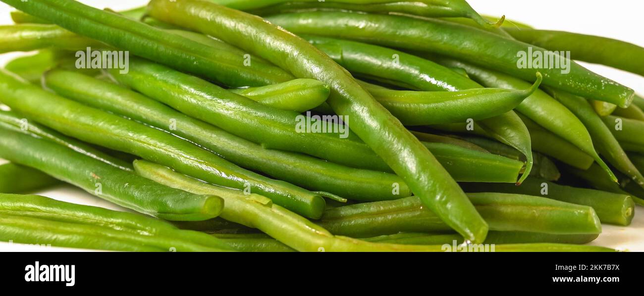 Nahaufnahme gekochte grüne Bohnen. Französische Streichbohnen, Haricots Verts, Nahaufnahme auf weißem Teller Stockfoto