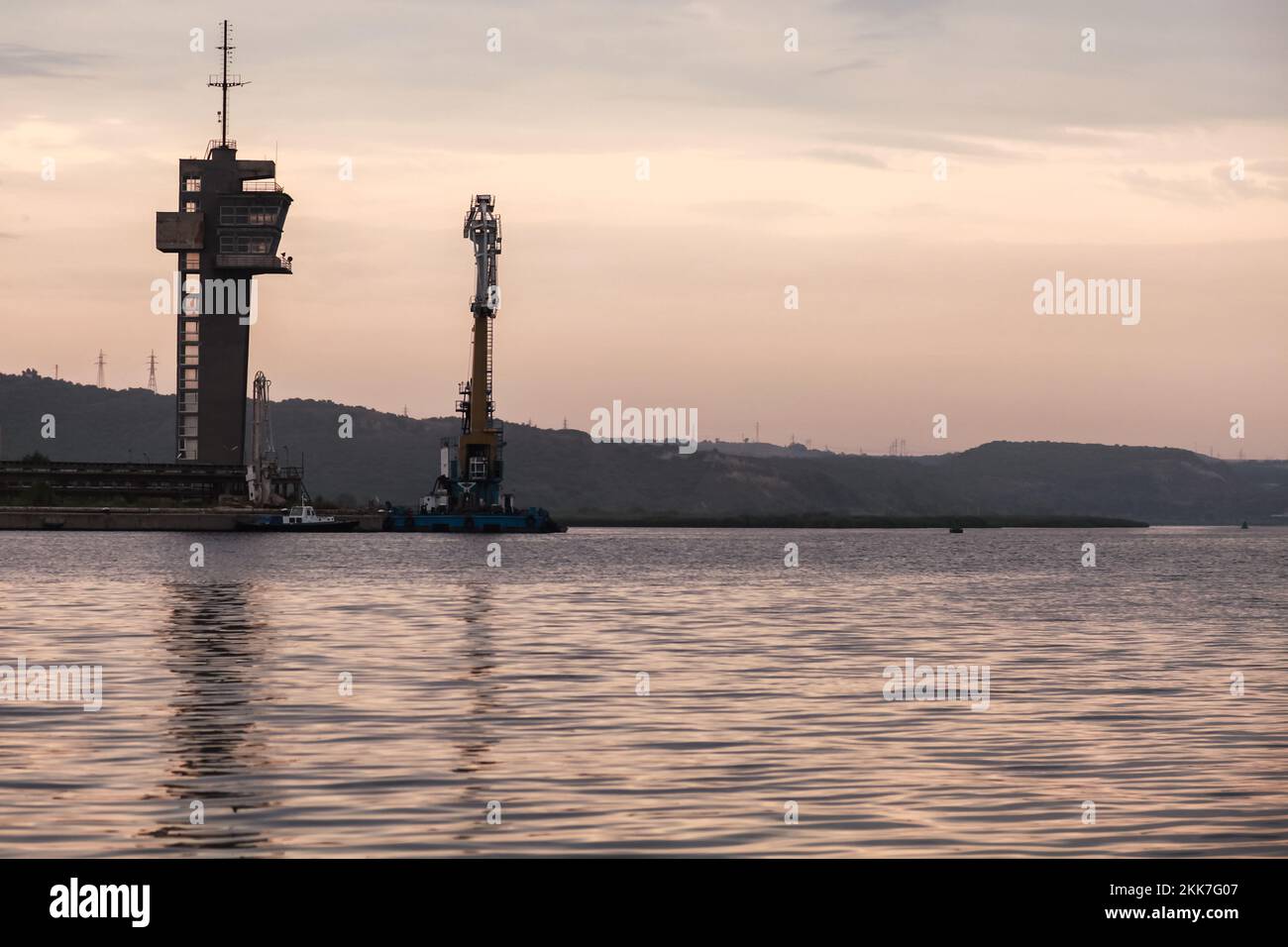 Küstenlandschaft mit Seeverkehrskontrollturm und schwimmendem Kran am Abend. Hafen von Varna, Bulgarien. Stockfoto