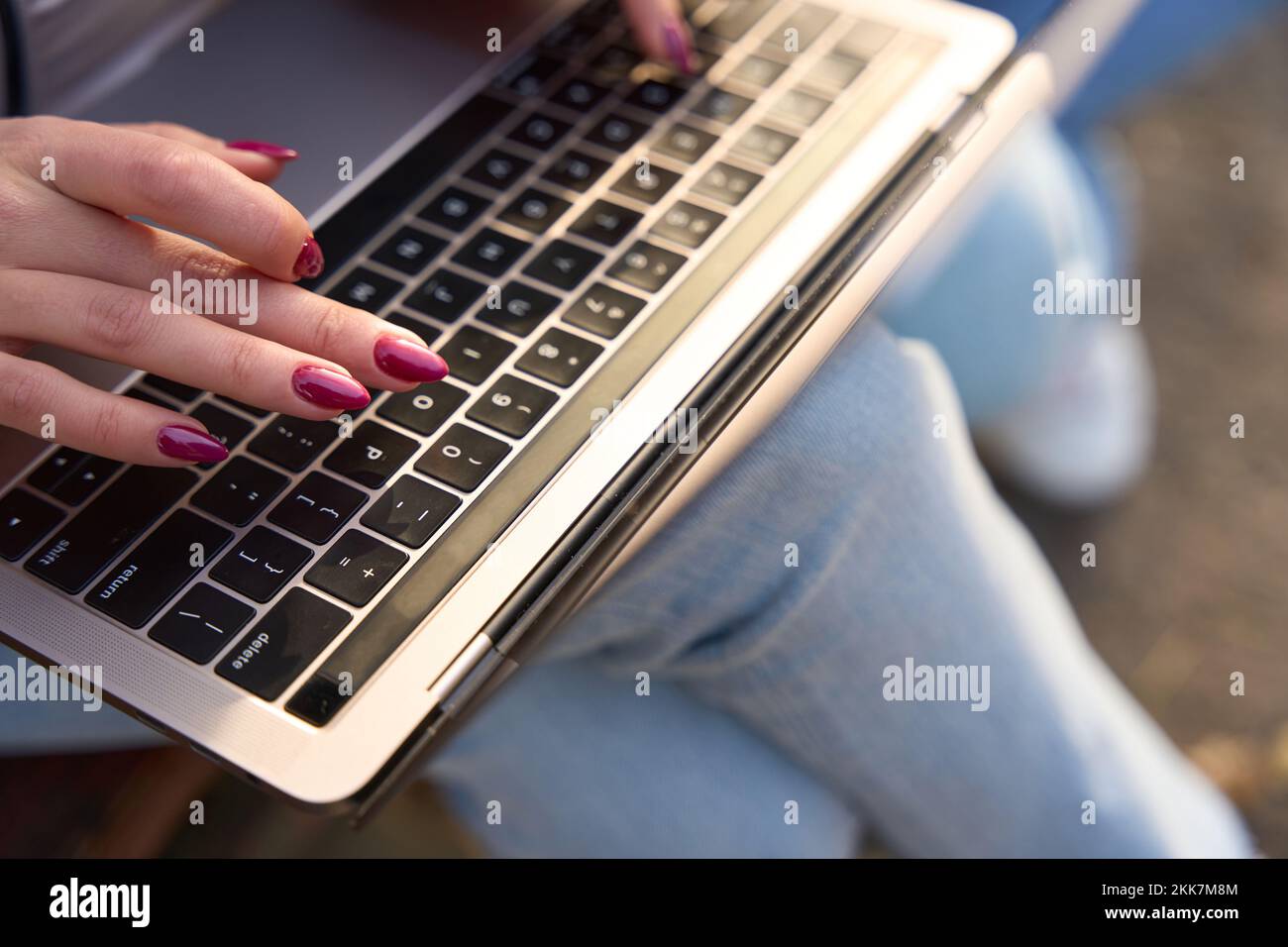 Eine Frau mit gut gepflegten Händen tippt Text auf die Tastatur Stockfoto