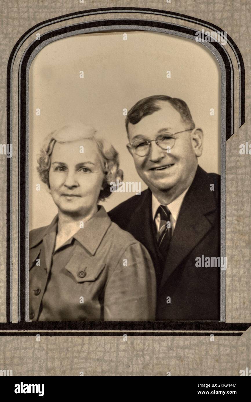 Lange verstorbene Großeltern des Fotografen Antique schwarz-weiß 1940er Jahre Porträt eines glücklichen älteren Ehepaars in Papprahmenmatte. Stockfoto