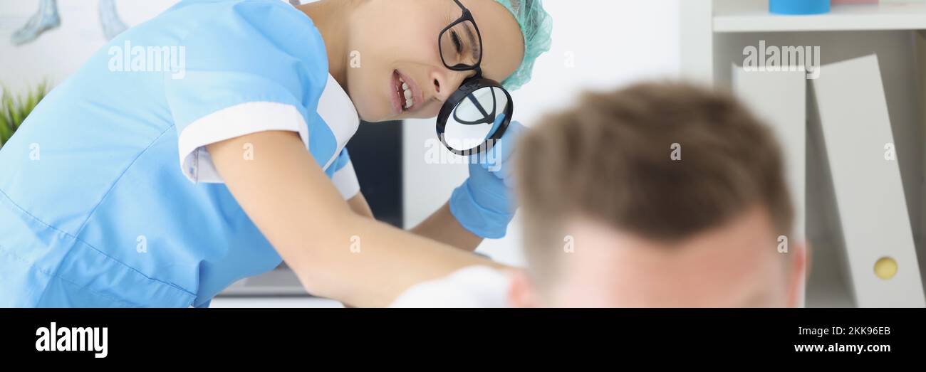 Frau Dermatologe untersuchen männlichen Patienten Körper, überprüfen Sie die Haut auf dem Rücken mit Lupe Stockfoto