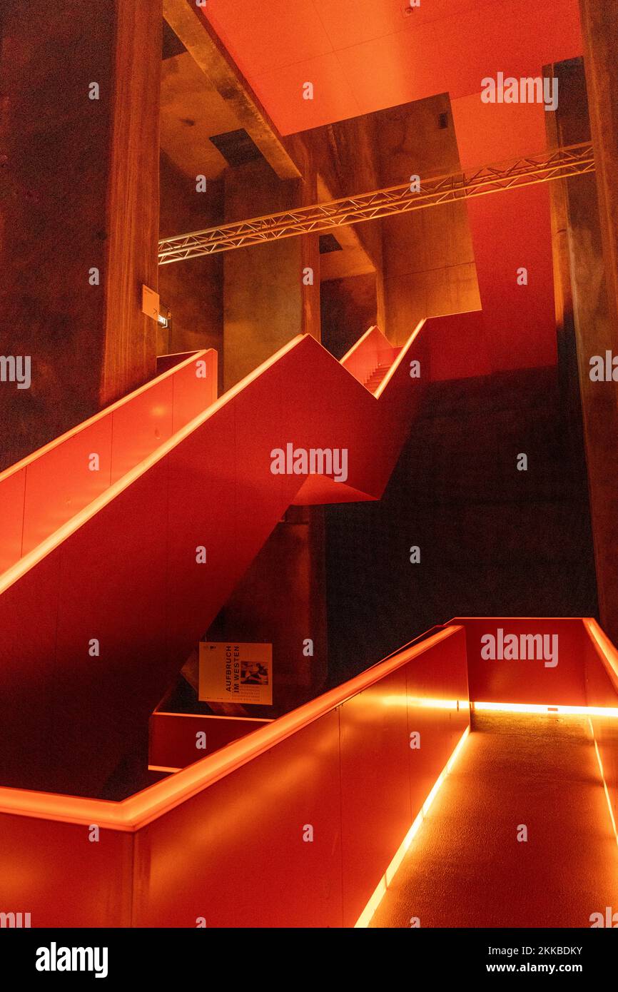 Essen, Deutschland - 23. Juli 2019: Innenansicht der schönen orange beleuchteten bemerkenswerten Treppe befindet sich am Eingang des Ruhrmuseums in der Zeche Stockfoto
