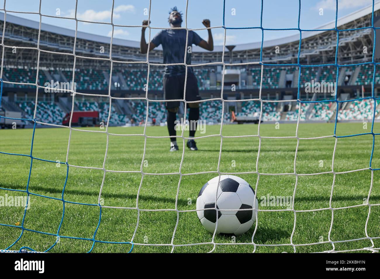 Der Fußballspieler schießt den Ball ins Tor des Stadions Stockfoto