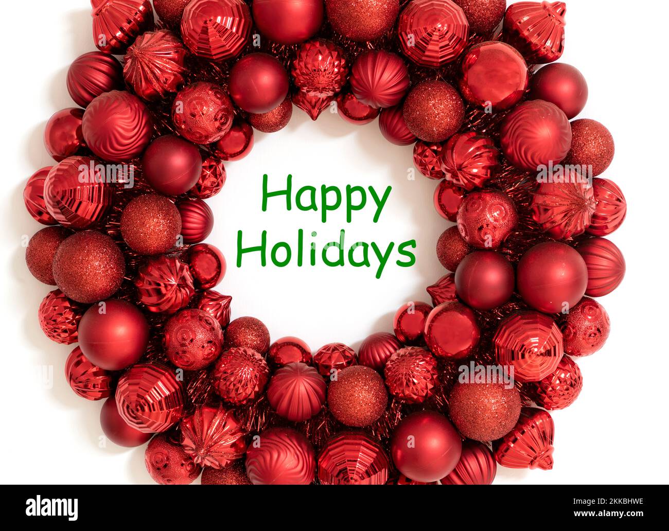 Frohe Weihnachten Grußkarte oder Hintergrund mit grünem Text zu frohen Feiertagen. Roter Kranz aus roten weihnachtsschmuck. Stockfoto
