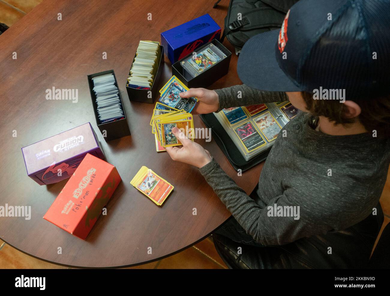 Austin Texas, USA, November 24 2022: Ein 14-jähriger Junge sortiert seine Pokemon-Kartensammlung während einer Pause in Thanksgiving-Dinner-Aktivitäten im Haus eines Verwandten. ©Bob Daemmrich Stockfoto