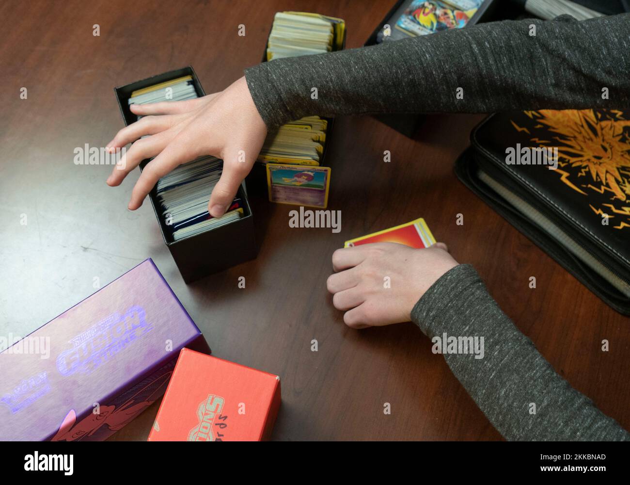 Austin Texas, USA, November 24 2022: Ein 14-jähriger Junge sortiert seine Pokemon-Kartensammlung während einer Pause in Thanksgiving-Dinner-Aktivitäten im Haus eines Verwandten. ©Bob Daemmrich Stockfoto