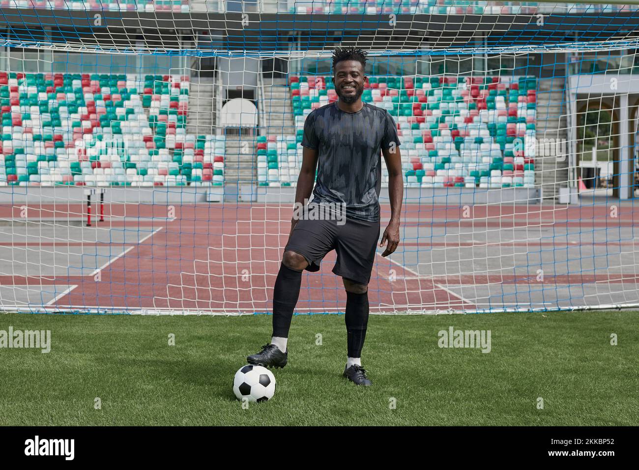 Ein Mann, der mit dem Fuß im Stadion Fußball hält Stockfoto