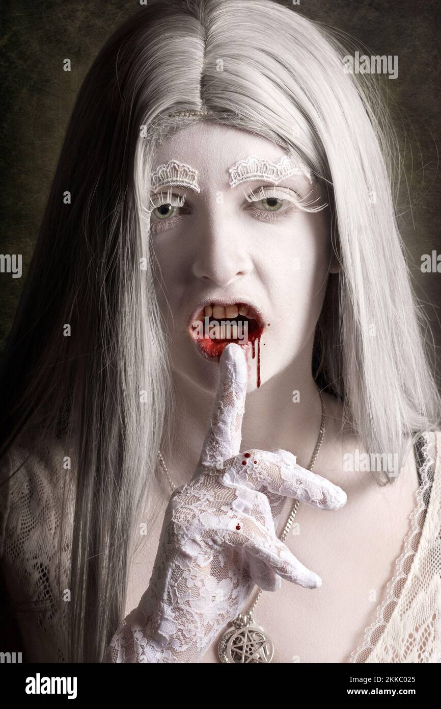 Bösen weißen Vampir Frau gestikulieren die Ruhe des Schweigens über dunklen Innenraum Hintergrund. Monster-Geheimnis Stockfoto