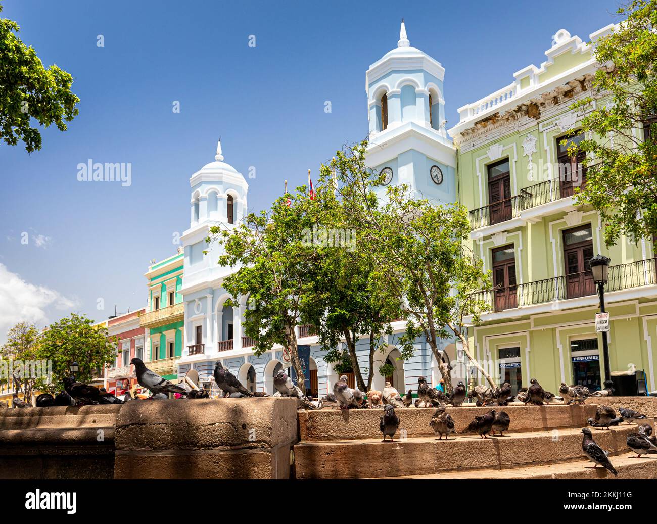 Tauben auf der Plaza de Armas mit Rathaus im Hintergrund in Old San Juan, auf der tropischen karibischen Insel Puerto Rico, USA. Stockfoto