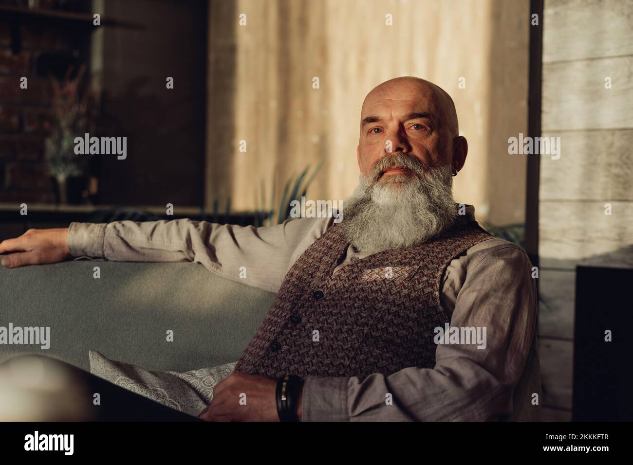 Reifer bärtiger Mann, der auf einem Stuhl sitzt. Stockfoto