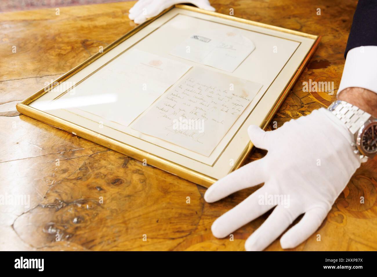 Leinfelden Echterdingen, Deutschland. 25.. November 2022. Das Stuttgarter Auktionshaus Eppli Auctions, neben anderen Objekten zum Thema „Britische Königsfamilie“, ein handgeschriebener zweiseitiger Brief der kürzlich verstorbenen Königin Elizabeth II (1926-2022) von 1966 an einen leidenschaftlichen Reiter. Ferdinand Eppli präsentiert das zu versteigernde Objekt. Es ist der gerahmte Brief, eine Kopie der Rückseite und der Umschlag. Kredit: Julian Rettig/dpa/Alamy Live News Stockfoto