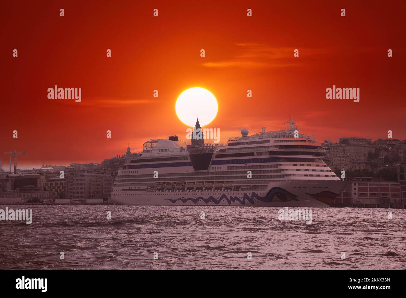 Landschaftlich reizvoller Hintergrund und Kreuzfahrtschiff für Tapeten oder Reiseführer. Feuriger Sonnenuntergang über dem Bosporus mit dem berühmten Galataturm Stockfoto