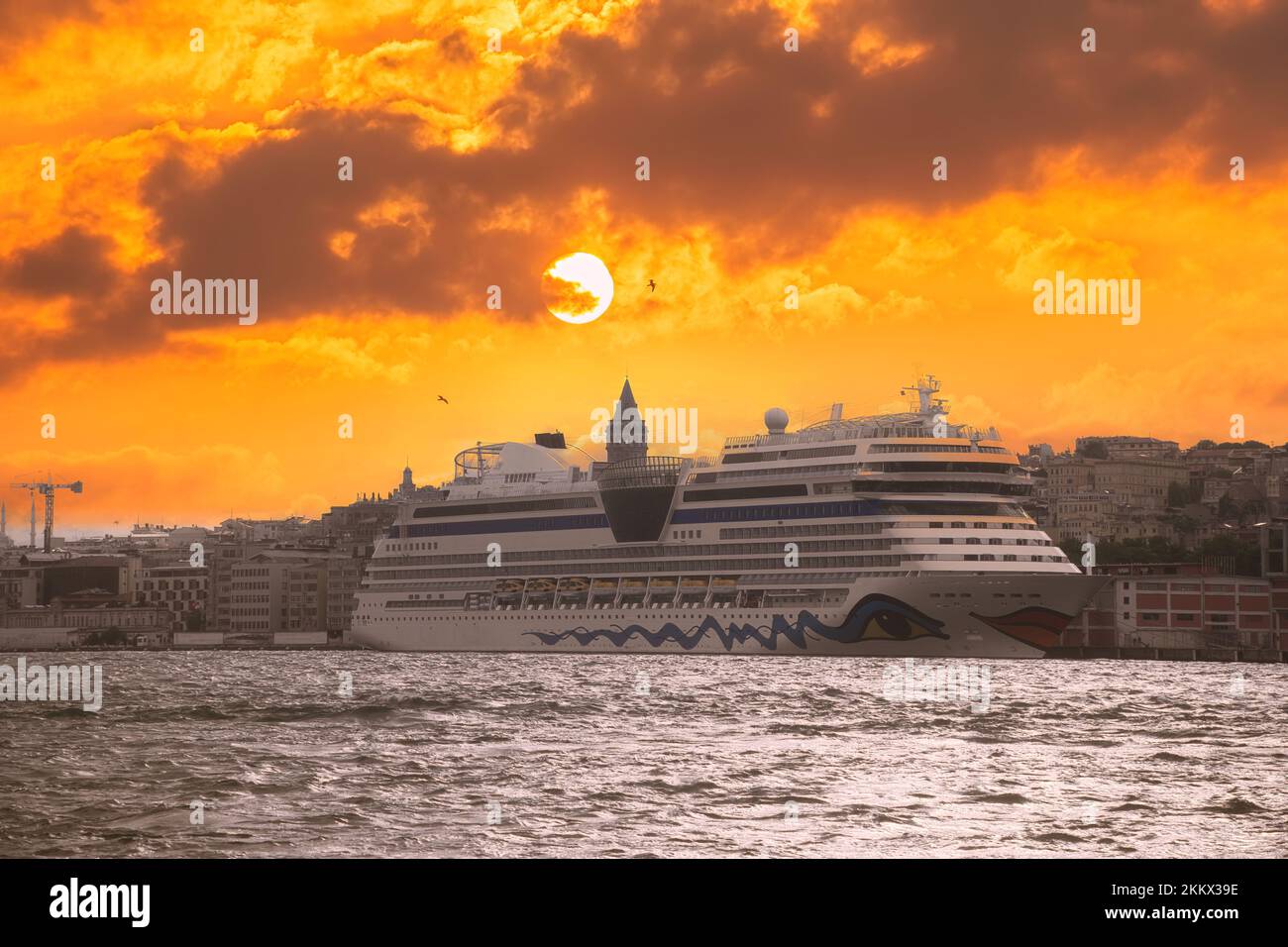 Landschaftlich reizvoller Hintergrund und Kreuzfahrtschiff für Tapeten oder Reiseführer. Feuriger Sonnenuntergang über dem Bosporus mit dem berühmten Galataturm Stockfoto