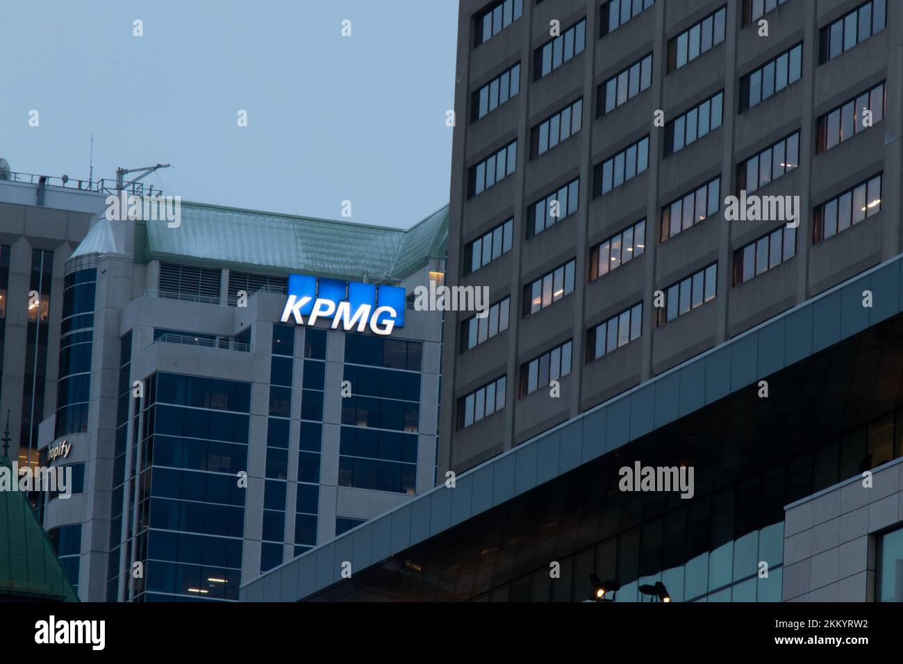 Das KPMG-Logo, eine professionelle Dienstleistungs- und Buchhaltungsfirma, ist am späten Nachmittag an der Seite eines Bürogebäudes in der Innenstadt von Ottawa beleuchtet. Stockfoto