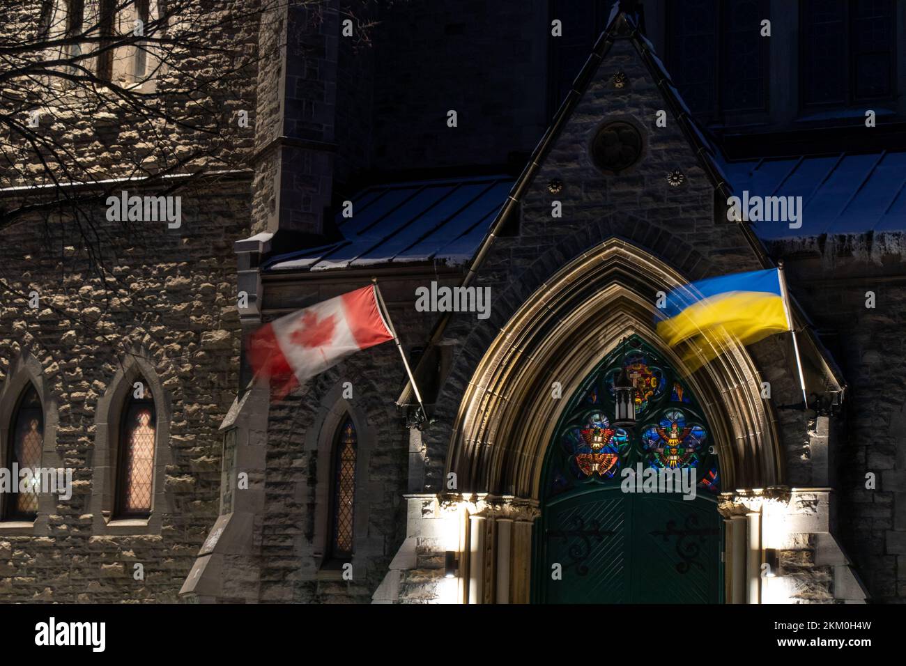 Am frühen Morgen sehen Sie ein Langzeitfoto der kanadischen und ukrainischen Flaggen zusammen über dem Eingang zu einer Presbyterianischen Kirche in Ottawa. Stockfoto
