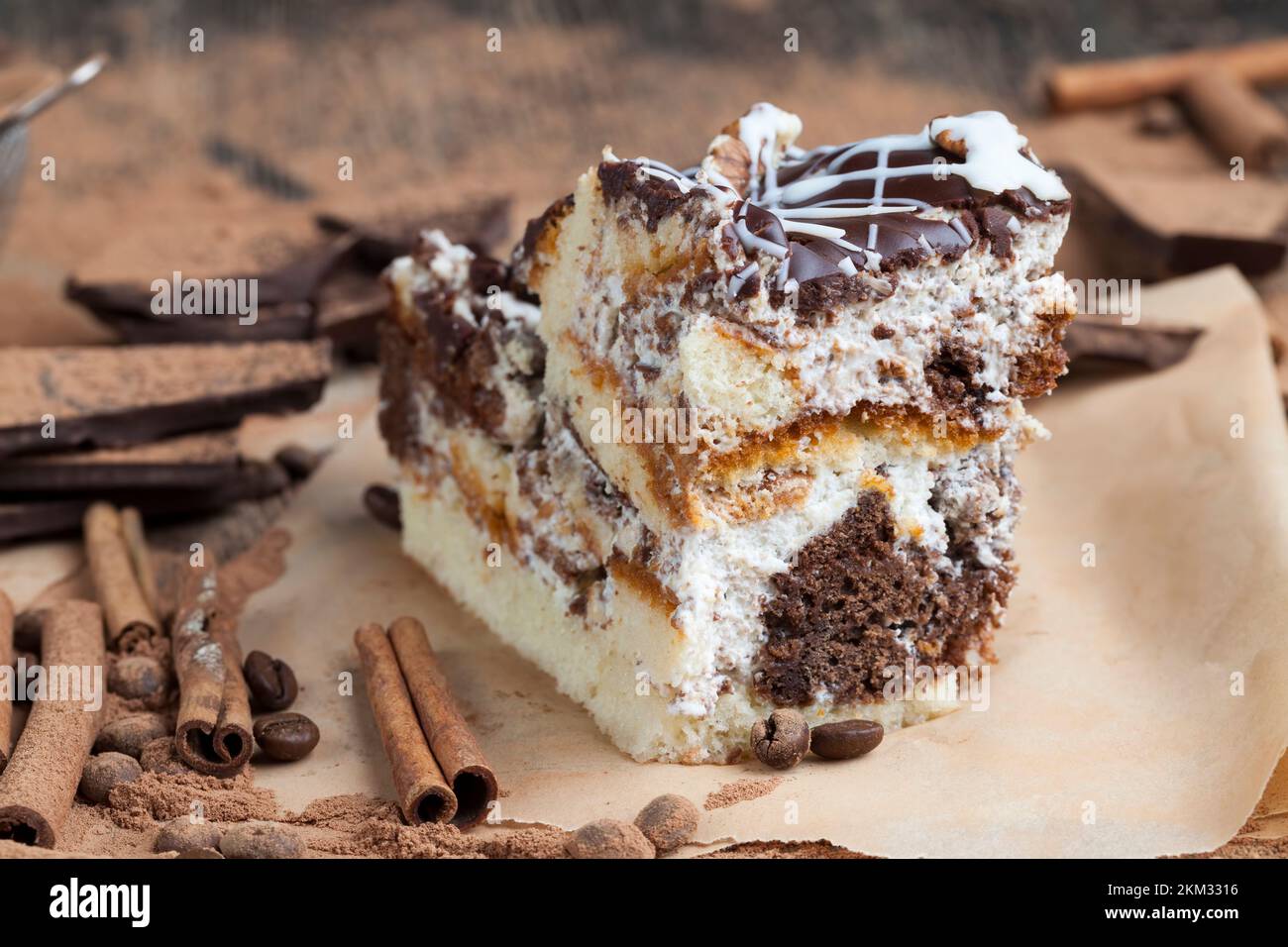 Ein mehrschichtiger Kuchen aus Schokolade und Cream Cakes in chaotischer Reihenfolge im Kuchen, es gibt viel Schokolade, Zimt und Kakaopulver Stockfoto