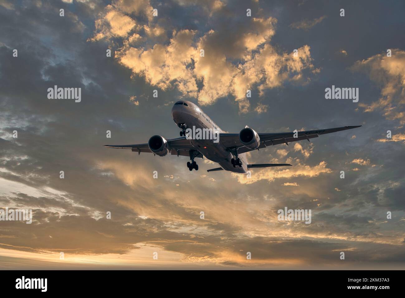 Horizontales Bild mit Kopierraum eines Flugzeugs, das bei einem wunderschönen Sonnenaufgang voller Passagiere am blauen Himmel landet Stockfoto