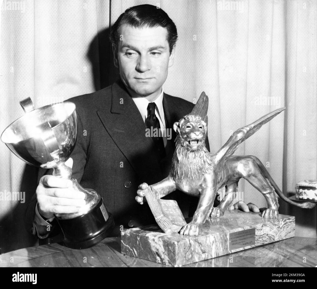 LAURENCE OLIVIER in seinem Chelsea-Heim im März 1949 mit seinen Auszeichnungen für den besten Schauspieler und den besten Film für seine Filmversion VON HAMLET, die auf dem 9.. Venice Film Festival vom 19.. August bis 4.. September 1948 verliehen wurde Stockfoto