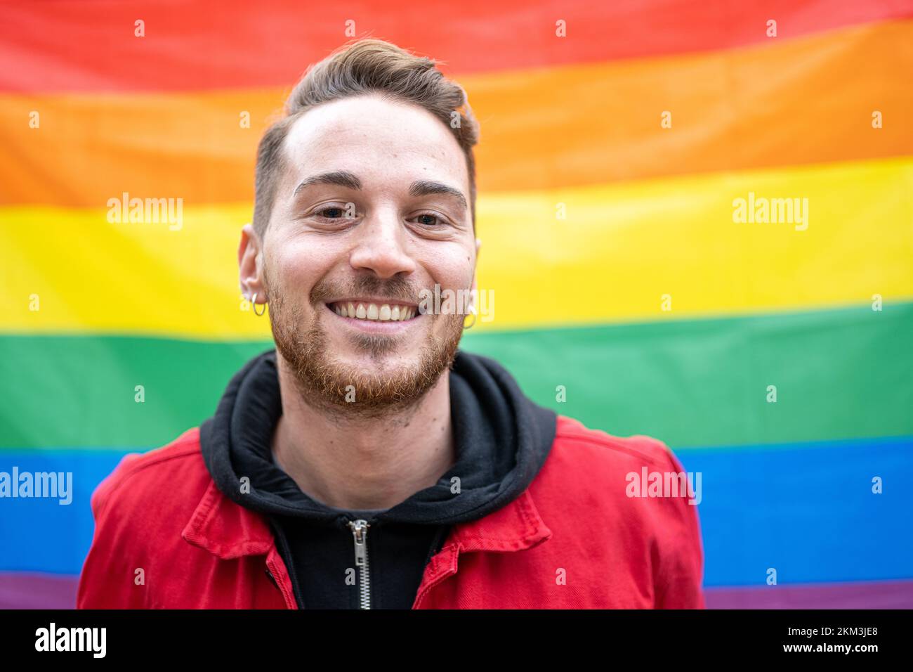 Porträt eines lächelnden Mannes, der seine schwule Identität annimmt, ein homosexueller Mann, der für Gleichheit und lgbt-Rechte eintritt, ein Homosexueller, Parabe und Stockfoto