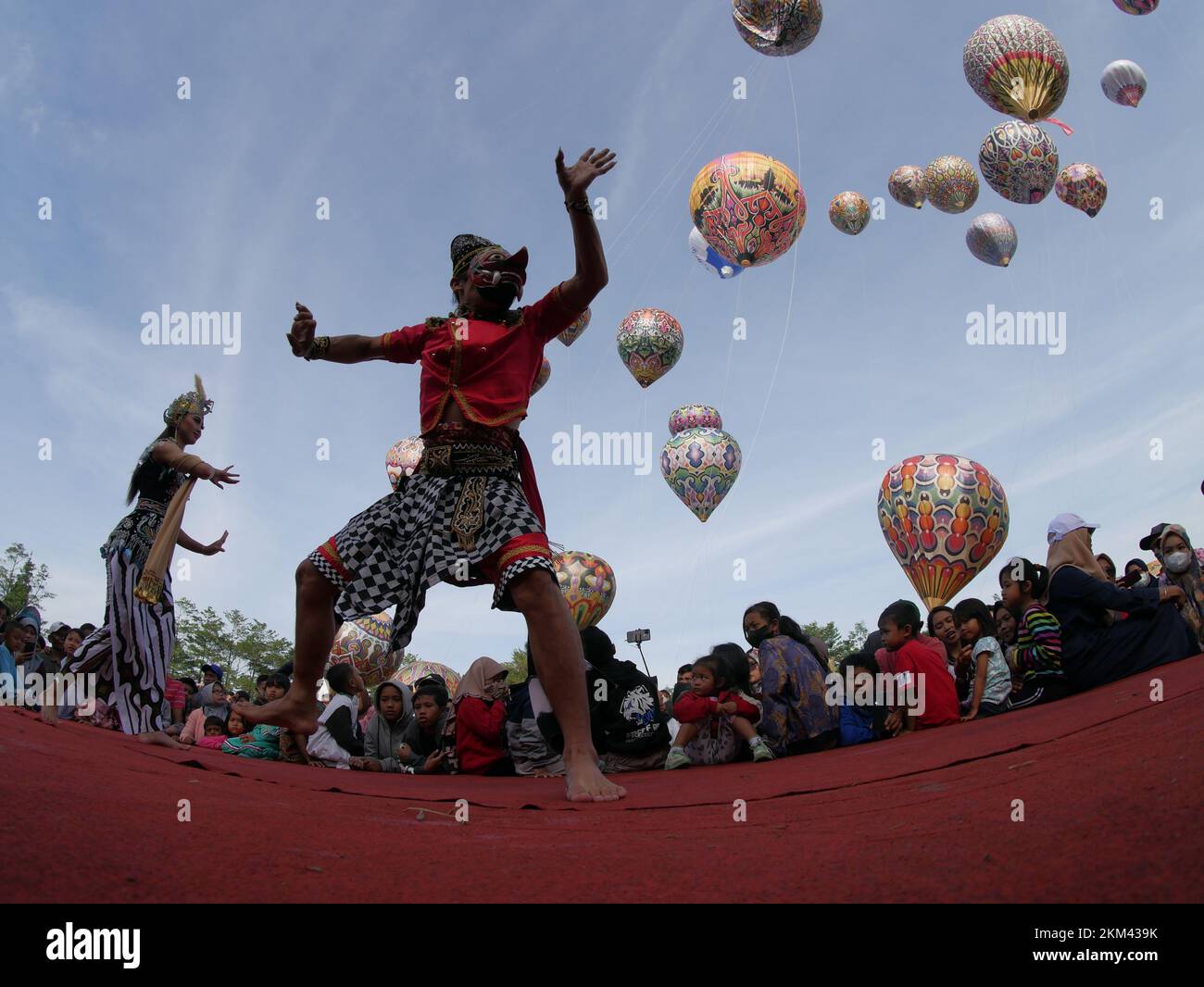 Lengger Tänzer aus Wonosobo Regency, Zentraljava, Indonesien tanzen vor dem Hintergrund von Heißluftballons Stockfoto