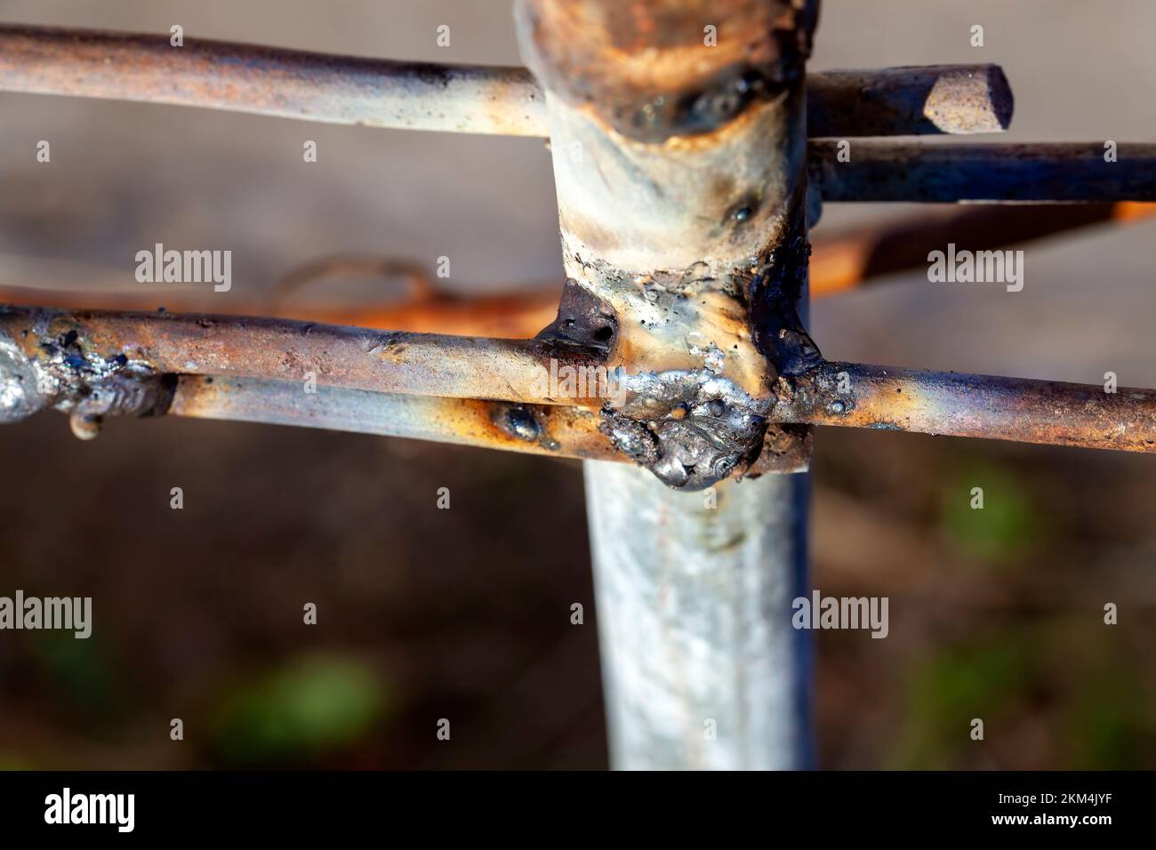 Zusammengeschweißte Befestigungsteile aus Metall, Teil eines rustikalen Zauns aus geschweißten Metallteilen Stockfoto
