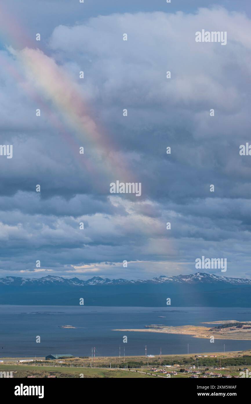 Nahaufnahme eines Regenbogens mit Bergen, Wolken und dem Ozean im Hintergrund. Stockfoto