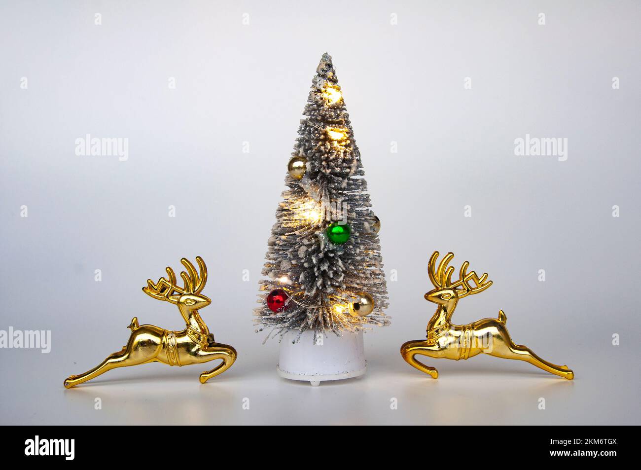 Rentier und Weihnachtsbaum auf weißem Hintergrund mit anpassbarem Platz für Text. Das Konzept der Weihnachtsfeier. Stockfoto