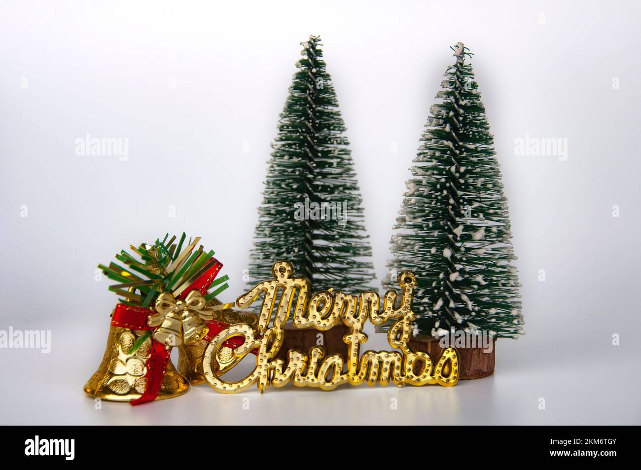 Frohe Weihnachtswünsche mit Weihnachtsglocken und Tress Hintergrund. Das Konzept der Weihnachtsfeier. Stockfoto
