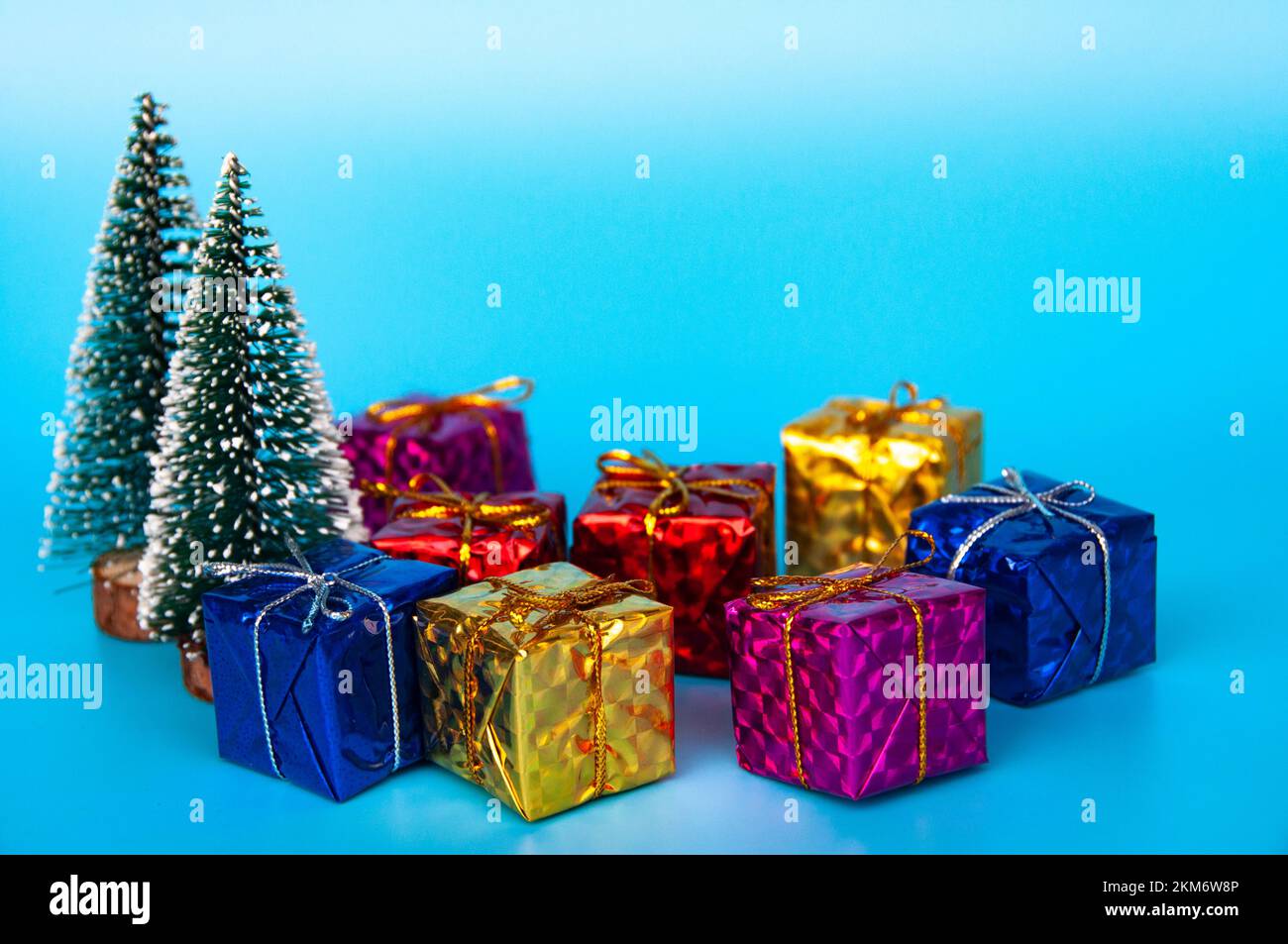 Weihnachtsgeschenke auf blauem Hintergrund mit anpassbarem Platz für Text. Das Konzept der Weihnachtsfeier. Stockfoto