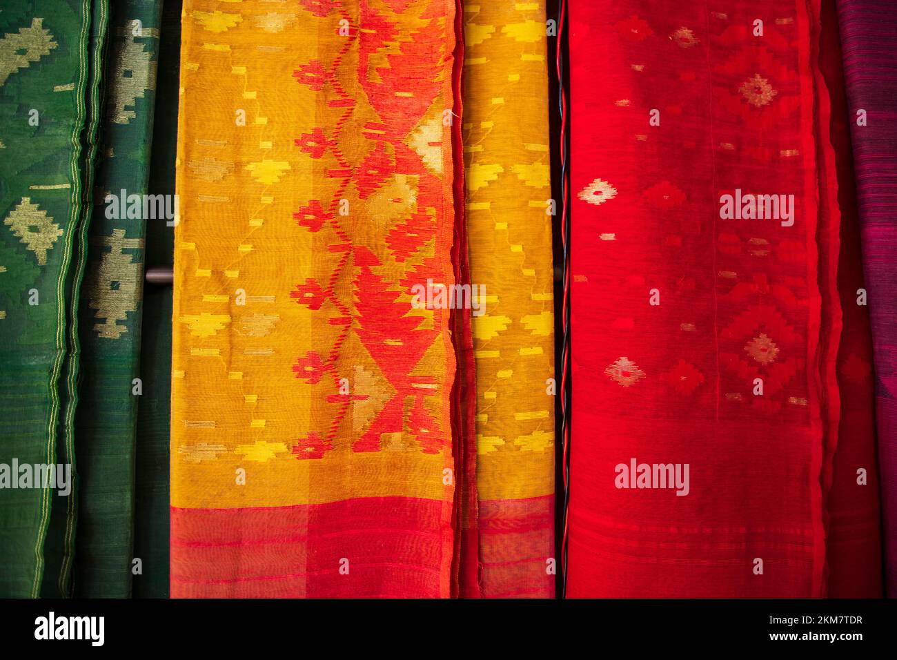 Bangladeshi Women, der traditionelle, farbenfrohe Jamdani-Saree, der in den Ausstellungsräumen des Einzelhandels hängt. Farbenfroher Jamdani Saree-Hintergrund Stockfoto