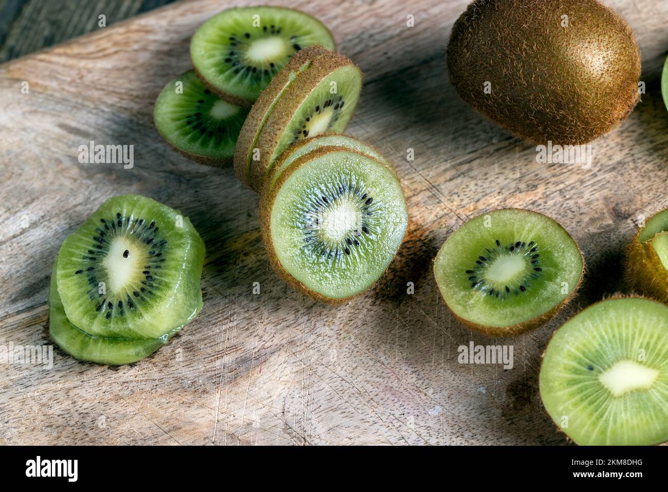 Reife grüne Kiwi auf einem Schneidebrett in Scheiben geschnitten, Kiwifrüchte gewaschen und in Stücke geschnitten Stockfoto