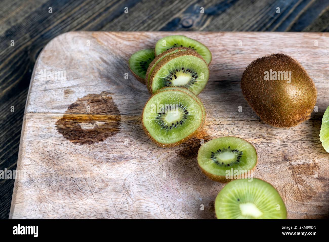 Reife grüne Kiwi auf einem Schneidebrett in Scheiben geschnitten, Kiwifrüchte gewaschen und in Stücke geschnitten Stockfoto
