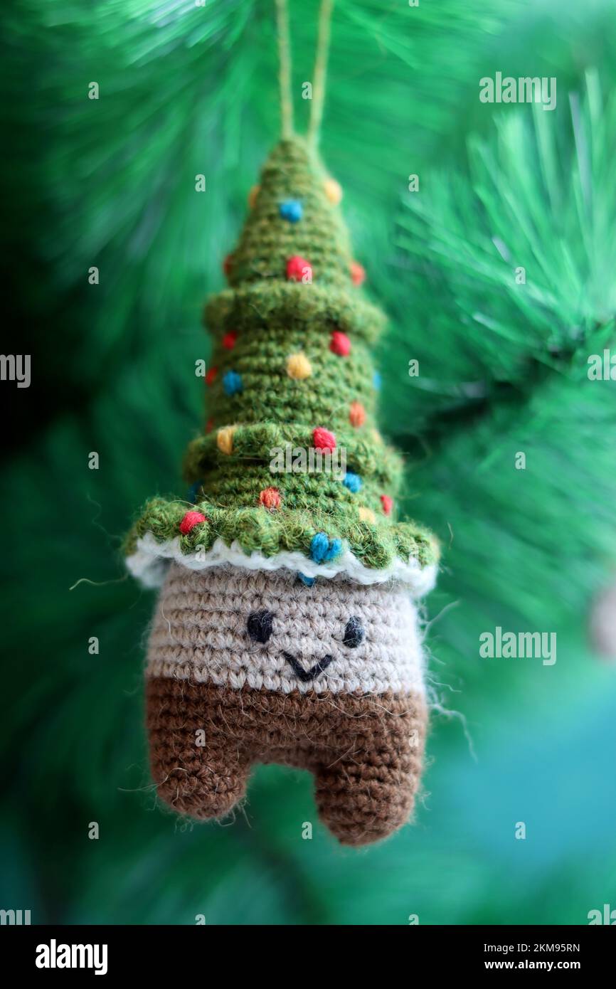 Gehäkelter Weihnachtsbaum. Süßes Amigurumi-Spielzeug aus Wollgarn. Stockfoto