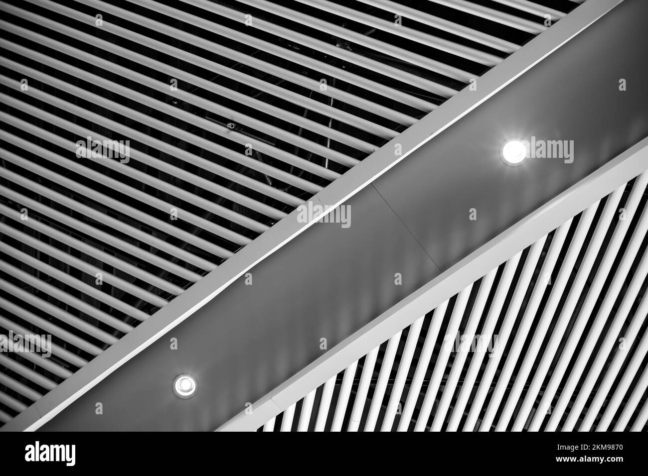 Abstrakte Textur von diagonalen Linien. Eiserne Decken der hohen Decke des Gebäudes mit Leuchtstrahlern. Stockfoto