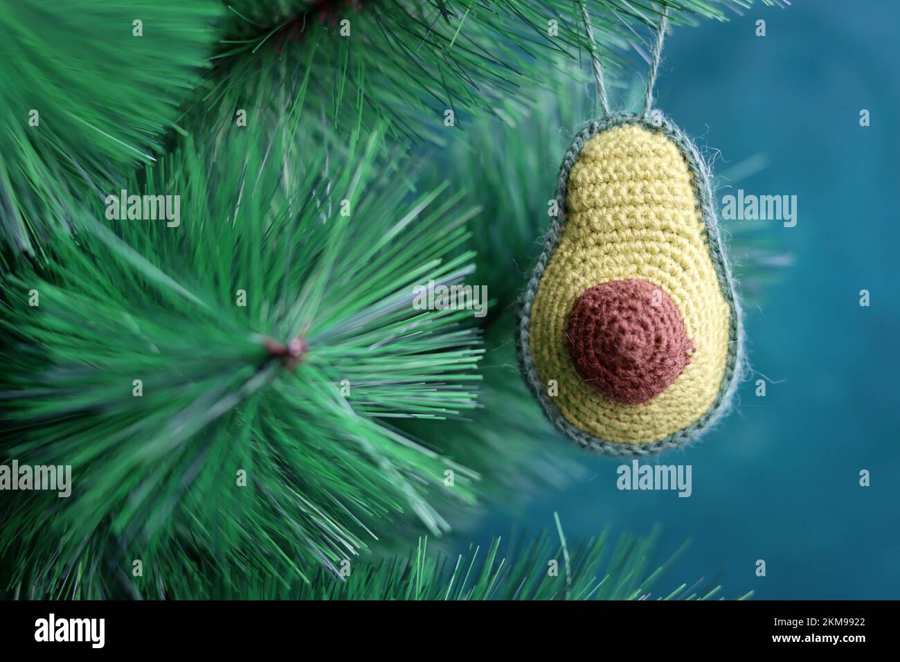 Gehäkelte Avocadofrüchte. Handgemachte grüne Teppichpuppe. Geschenkideen für Weihnachten. Umweltfreundliches Spielzeug aus natürlichen Materialien. Stockfoto