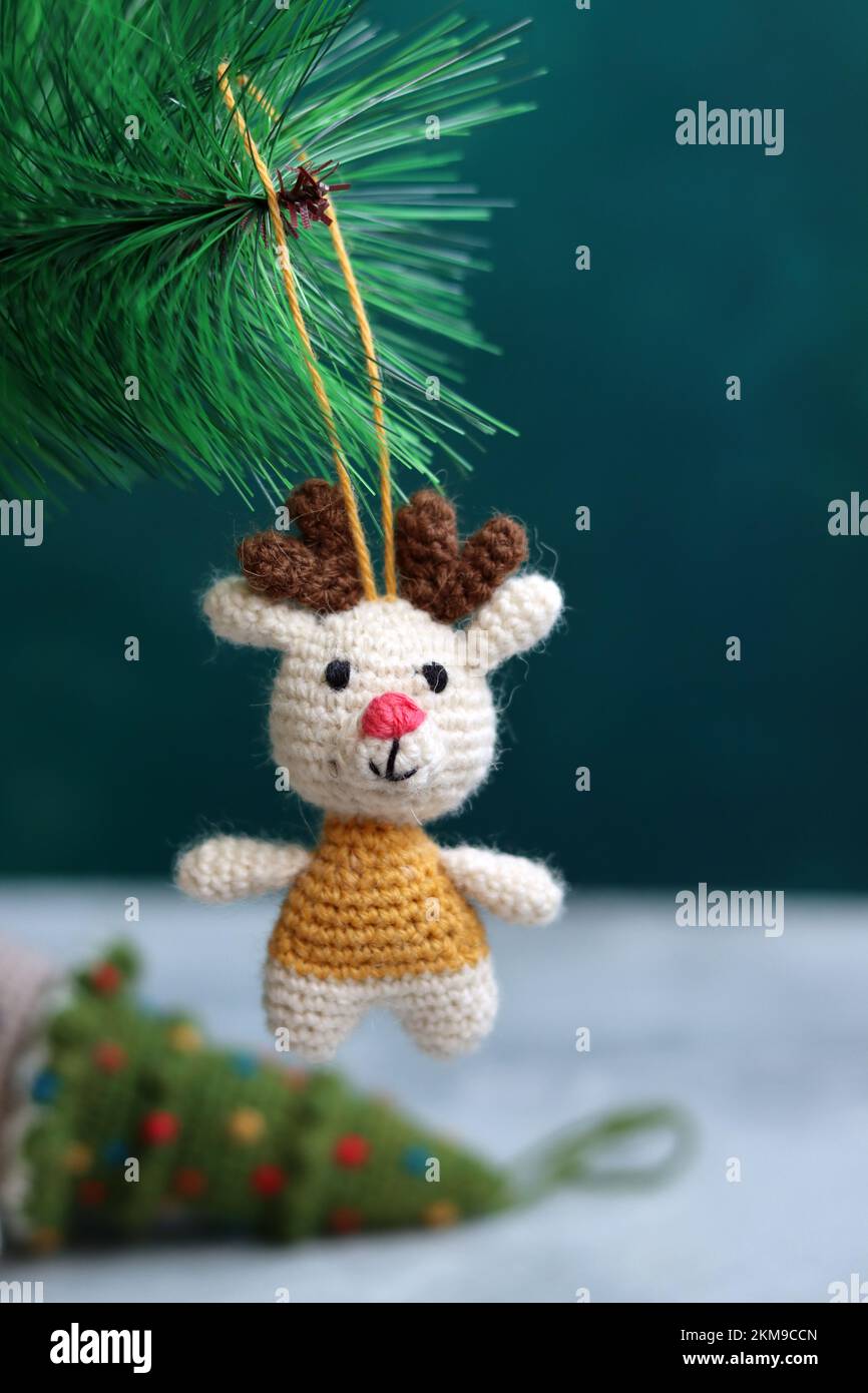 Häkelschmuck als Weihnachtsdekoration auf einem Baum. Süßes Amigurumi-Spielzeug auf einem grünen Weihnachtsbaum. Stockfoto