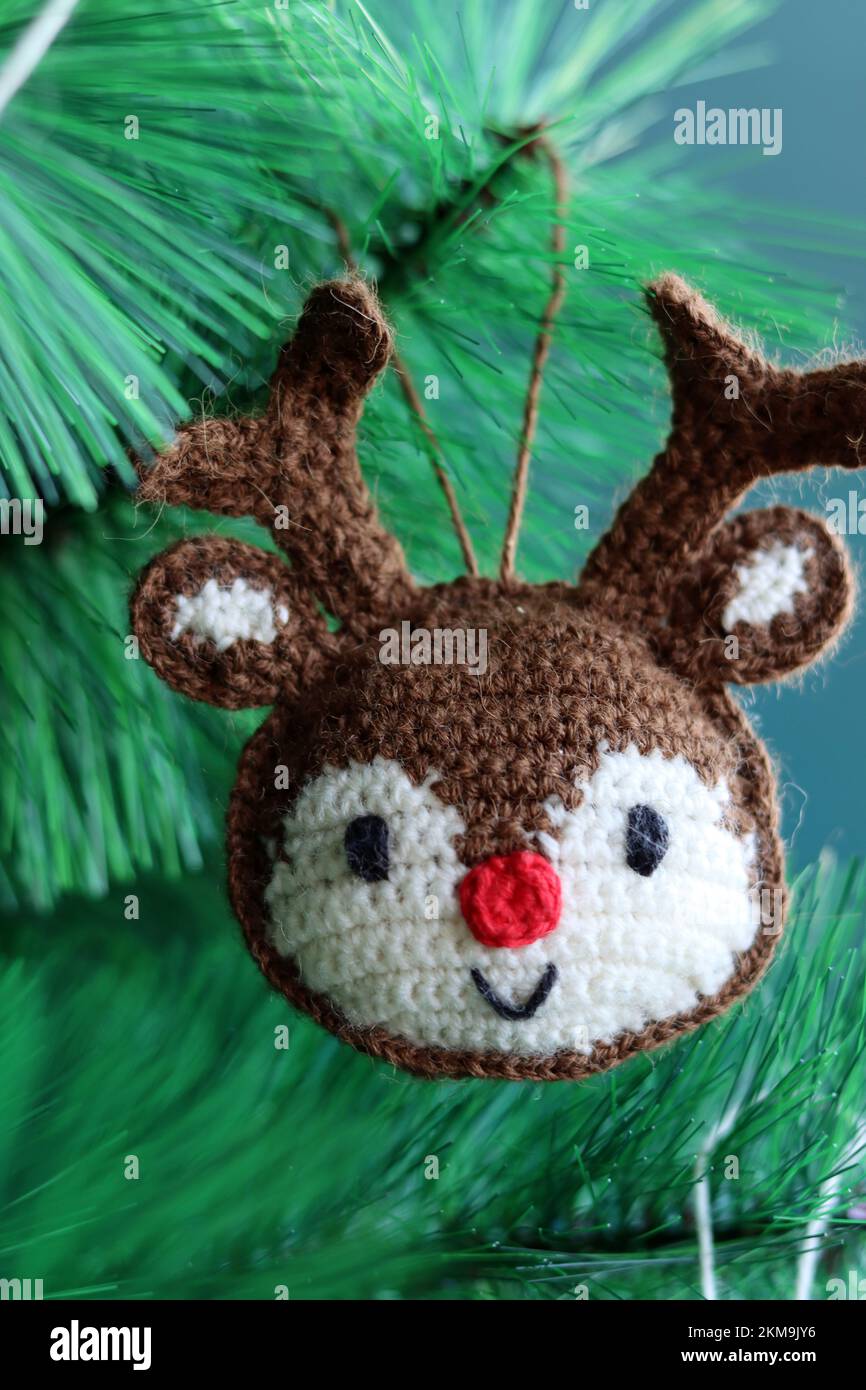 Häkelschmuck als Weihnachtsdekoration auf einem Baum. Süßes Amigurumi-Spielzeug auf einem grünen Weihnachtsbaum. Stockfoto