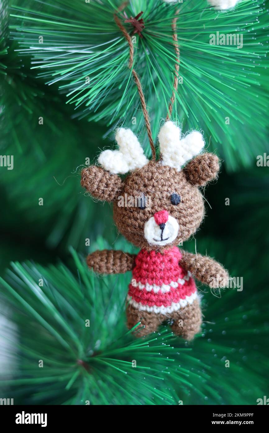 Häkelschmuck als Weihnachtsdekoration auf einem Baum. Süßes Amigurumi-Spielzeug auf einem grünen Weihnachtsbaum. Stockfoto