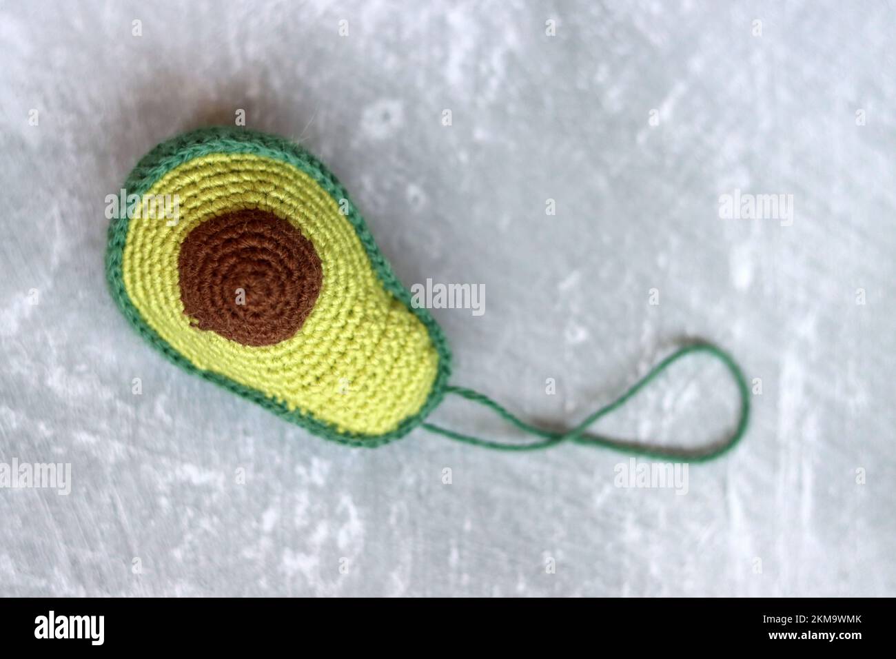 Gehäkelte Avocadofrüchte. Handgemachte grüne Teppichpuppe. Geschenkideen für Weihnachten. Umweltfreundliches Spielzeug aus natürlichen Materialien. Stockfoto