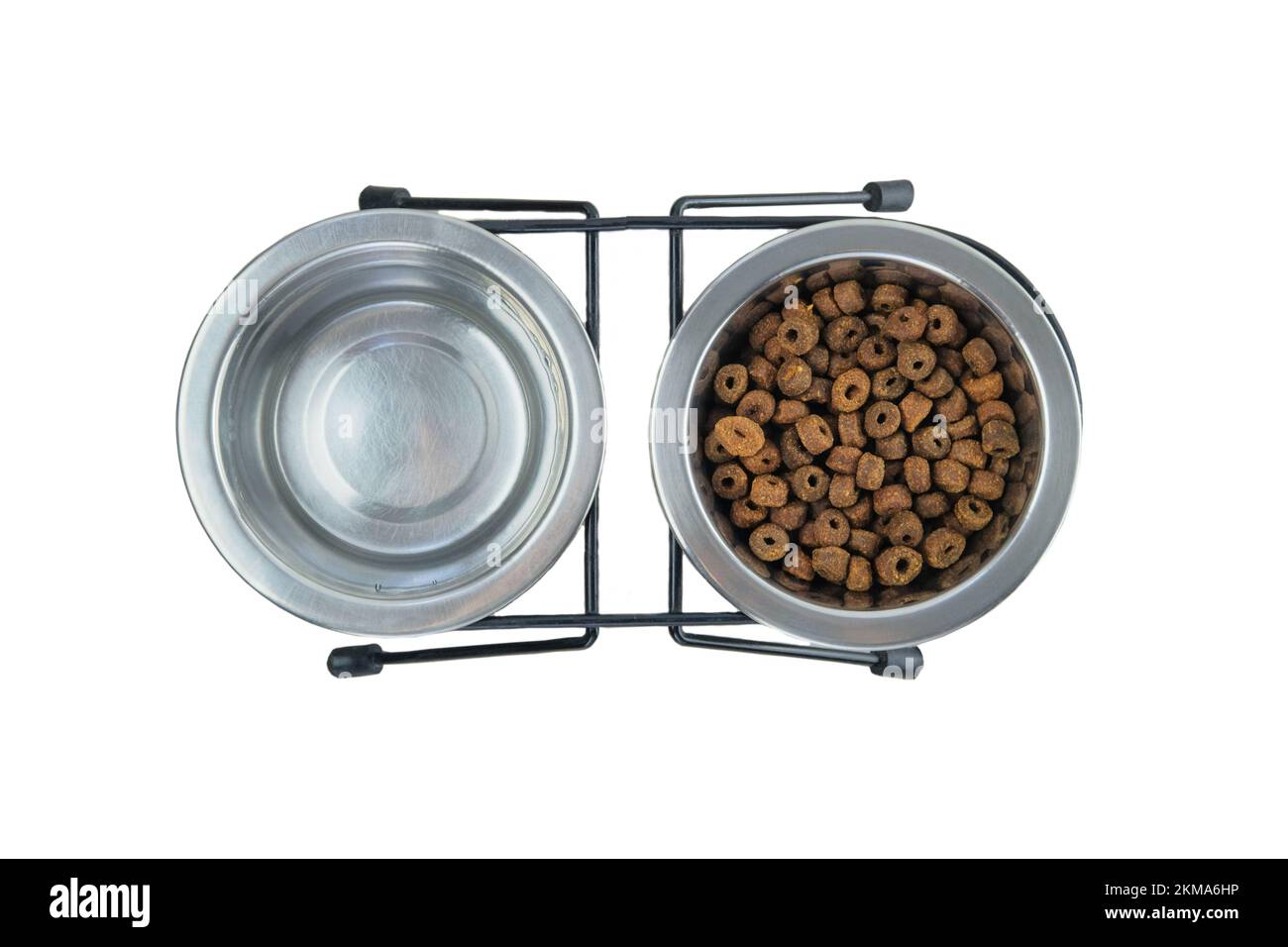Trockenfutter und Wasser für Katzen und Hunde in Metallschalen, isoliert auf weißem Hintergrund. Draufsicht. Stockfoto