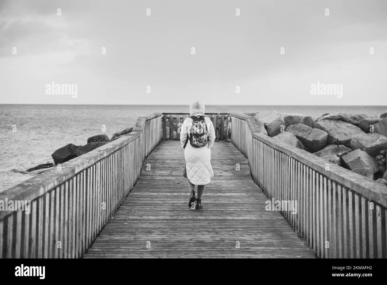 Eine einsame Frau, die auf einem Pier in Dänemark spaziert Stockfoto