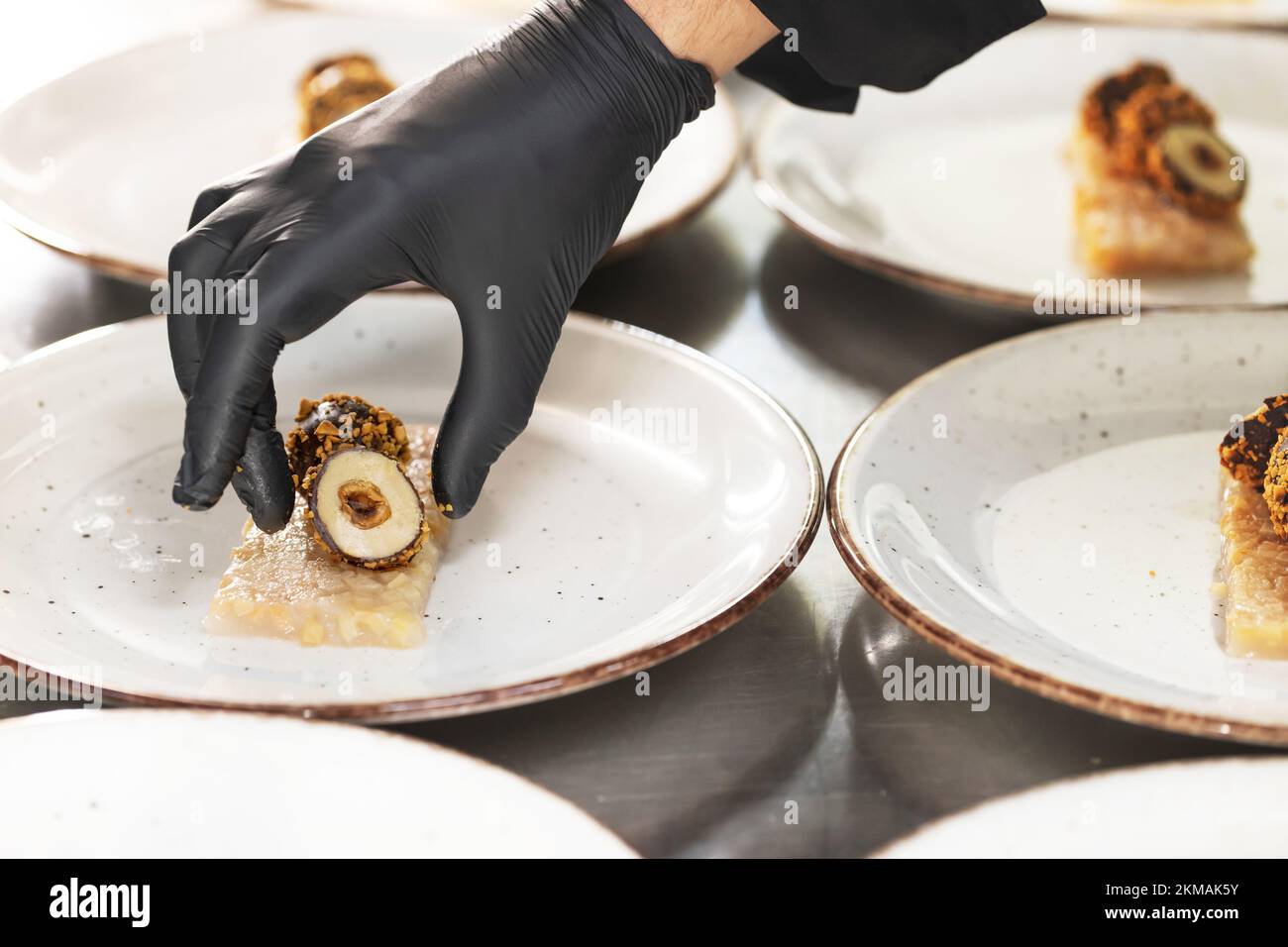 Koch bereitet kreative Vorspeise aus Entenleberpastete mit Schokoladenmantel auf Quittengelee zu Stockfoto
