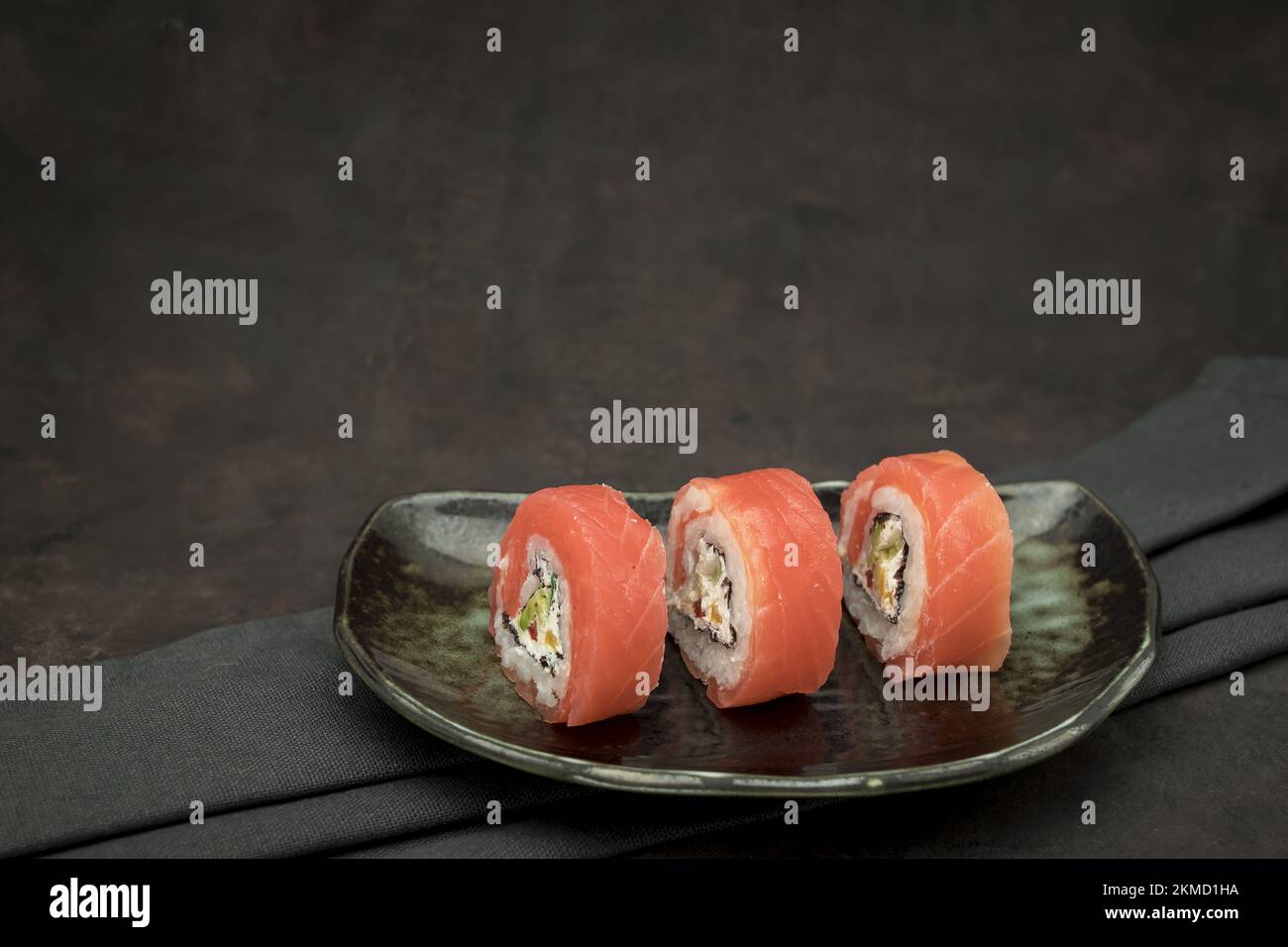 Foto von köstlichem Sushi auf dunklem Hintergrund Stockfoto