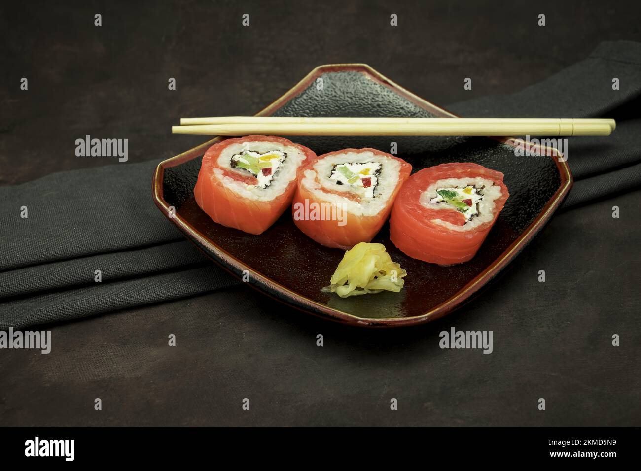Foto von köstlichem Sushi auf dunklem Hintergrund Stockfoto