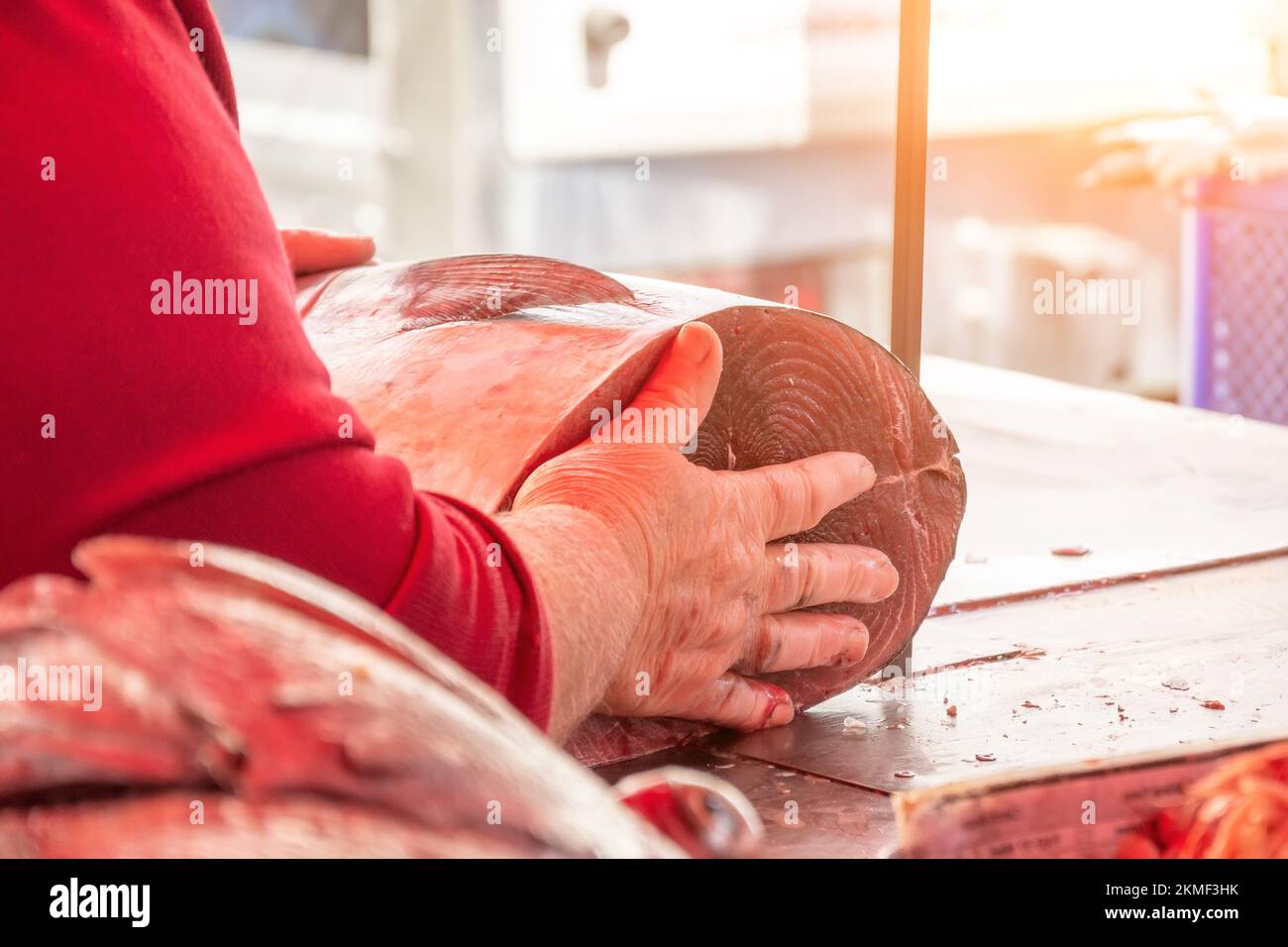 Schneiden von Schlachtkörpern von Fischfleischstücken in einer Säge zum Verkauf auf dem Fischmarkt Stockfoto