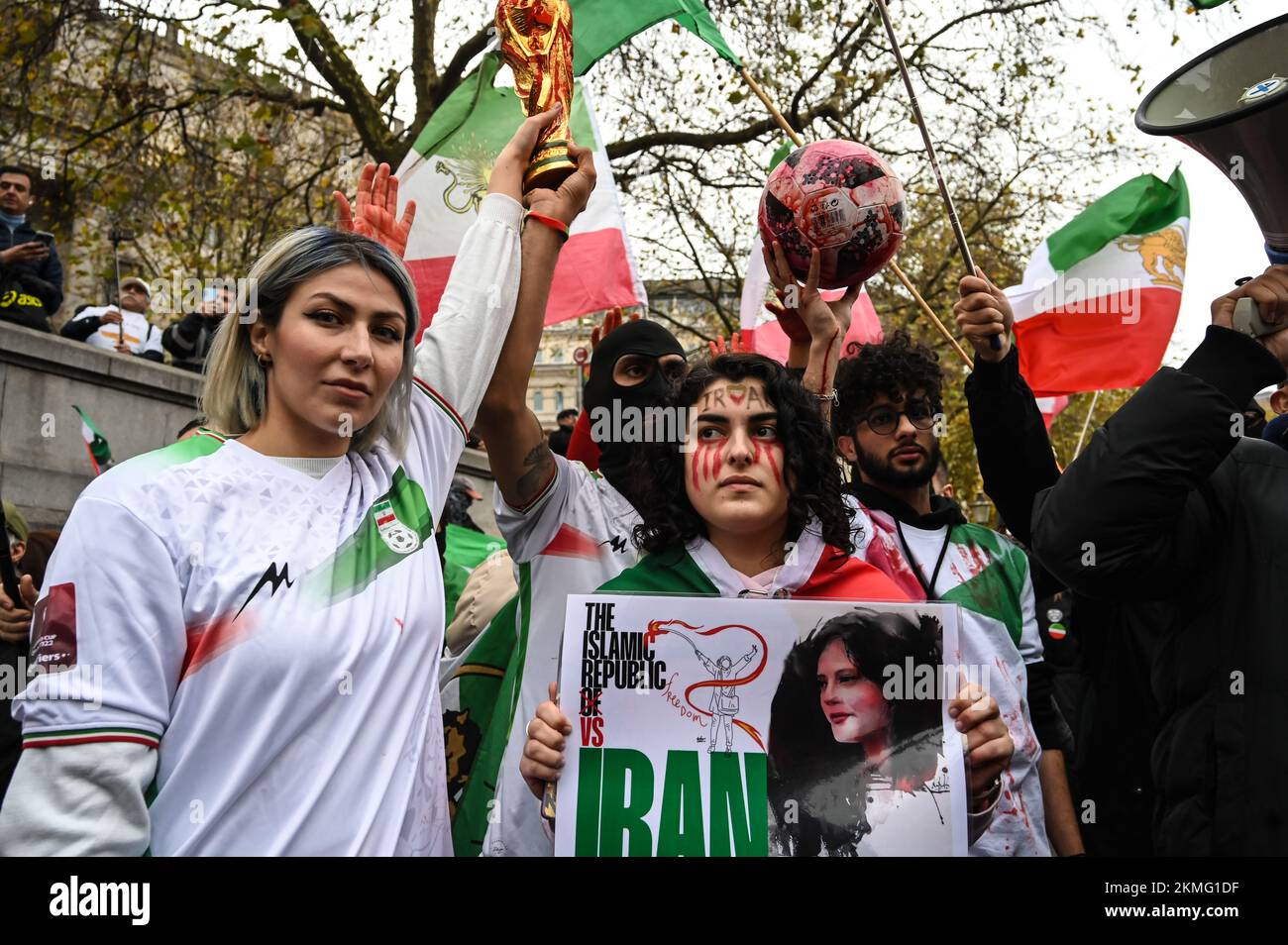 Trafalgar Square, London, Großbritannien. 26.. November 2022: Protest gegen die iranische Regierung und Demonstranten der Katar-Weltmeisterschaft, die Teheran mit Flaggen und Bannern kritisierten und einen Fußball und eine gefälschte WM-Trophäe mit falschem Blut überhielten. Stockfoto
