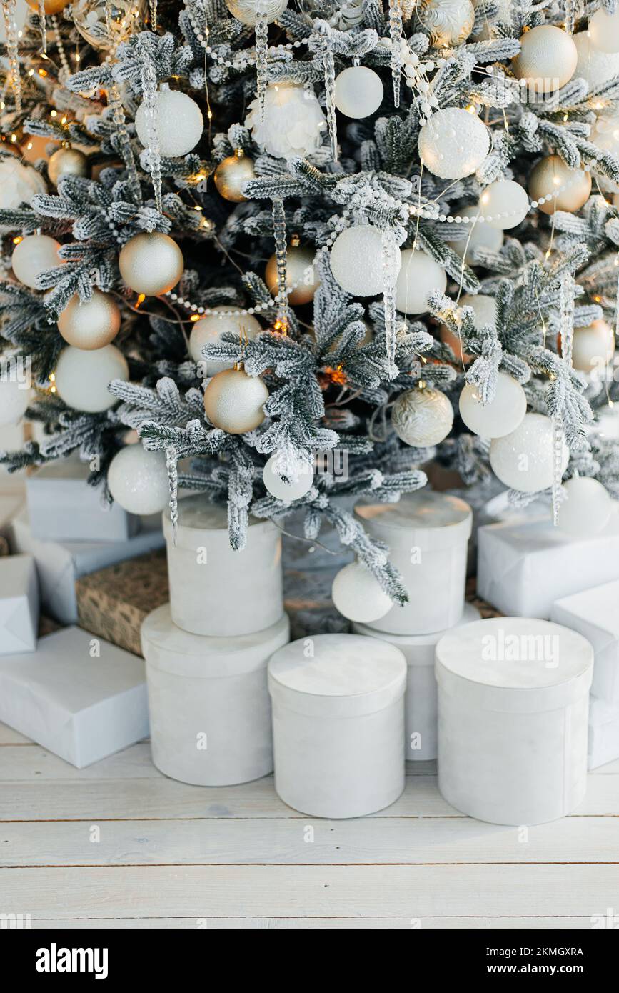 Stapel von Geschenkschachteln in der Nähe des schönen Weihnachtsbaums im Innenbereich Stockfoto